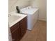 Practical laundry room with modern washer and dryer, sleek dark cabinets, and convenient overhead rack at 7112 Whitford St, Las Vegas, NV 89166