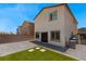 Fully fenced backyard with patio and small faux grass yard, along with exterior building view at 7432 Red Plumeria Ave, Las Vegas, NV 89113