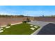 This backyard features a brick patio, faux grass, and concrete pavers at 7432 Red Plumeria Ave, Las Vegas, NV 89113