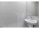 Elegant bathroom featuring a sleek pedestal sink and a large frameless mirror at 7432 Red Plumeria Ave, Las Vegas, NV 89113