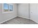 Bedroom with wood-look floors, natural light from window, and interior door at 7432 Red Plumeria Ave, Las Vegas, NV 89113
