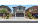 Two-story home featuring a paved driveway, gray stucco, and attached garage, and manicured landscape at 7432 Red Plumeria Ave, Las Vegas, NV 89113
