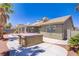 The backyard includes a hot tub, desert landscaping, covered patio, and exterior features at 7713 White Grass Ave, Las Vegas, NV 89131