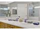 Bright bathroom features a double sink vanity with modern fixtures and a tiled shower at 7713 White Grass Ave, Las Vegas, NV 89131