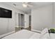 This bedroom offers mirrored closet doors, a ceiling fan, and an ensuite bathroom at 7713 White Grass Ave, Las Vegas, NV 89131