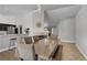 Bright dining room with modern chandelier and tile floors, open to the kitchen and living area at 7713 White Grass Ave, Las Vegas, NV 89131