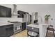 Modern kitchen with stainless steel appliances, black cabinetry, quartz countertops and breakfast bar at 7713 White Grass Ave, Las Vegas, NV 89131