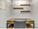 Home office with a wooden desk, open shelving, and a comfortable chair for work at 7713 White Grass Ave, Las Vegas, NV 89131
