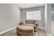Cozy sitting area with wood-look flooring, a plush armchair, and a bright window at 7713 White Grass Ave, Las Vegas, NV 89131