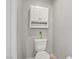 Clean white toilet beneath a wall cabinet, offering a minimalist and functional design at 7713 White Grass Ave, Las Vegas, NV 89131