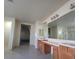 Well-lit bathroom with double sinks, a large mirror, and tile flooring at 7728 Villa De La Paz Ave, Las Vegas, NV 89131