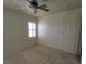 Neutral bedroom with a ceiling fan, window, and a standard closet door at 7728 Villa De La Paz Ave, Las Vegas, NV 89131