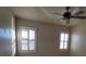 Bedroom with two windows, neutral walls, and ceiling fan for added comfort at 7728 Villa De La Paz Ave, Las Vegas, NV 89131