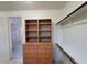 Walk-in closet with wooden storage dresser and racks, plus a peek into the bathroom at 7728 Villa De La Paz Ave, Las Vegas, NV 89131