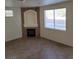 Living room with a cozy fireplace, tile flooring, and a bright window at 780 Vortex Ave, Henderson, NV 89002
