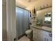 Bright bathroom featuring a shower with a blue curtain, a white vanity, and decorative shelving at 790 Fort Churchill Rd, Pahrump, NV 89060