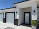 Inviting front entrance with modern trim and a well-maintained two-car garage at 790 Fort Churchill Rd, Pahrump, NV 89060