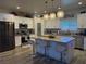 Bright, modern kitchen featuring a large island, stainless steel appliances, and stylish pendant lighting at 790 Fort Churchill Rd, Pahrump, NV 89060