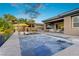 A luxurious pool and spa with a sunny umbrella and lounge chairs are surrounded by palm trees at 8 Reflection Cove Dr, Henderson, NV 89011