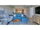 Comfortable living room featuring a modern blue sectional and decor and access to the kitchen at 8255 Las Vegas S Blvd # 1414, Las Vegas, NV 89123