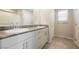 Modern bathroom featuring dual sinks with granite countertops, tiled flooring, and a walk-in shower at 8278 Palladium St, Las Vegas, NV 89113