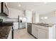 Modern kitchen with stainless steel appliances and an island with a sink overlooking the living space at 8278 Palladium St, Las Vegas, NV 89113