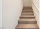 Carpeted stairs lead to the upper level of the home, with a bright white wall and railing at 8278 Palladium St, Las Vegas, NV 89113