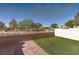Backyard with a low brick wall, rock landscaping, white vinyl fencing, and synthetic grass at 8843 Tomnitz Ave # 102, Las Vegas, NV 89178