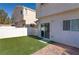 Backyard with synthetic grass, a brick patio, and a white vinyl fence surrounding the yard at 8843 Tomnitz Ave # 102, Las Vegas, NV 89178