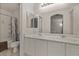 Bathroom with double sinks, white cabinets, a large mirror, and a shower and toilet at 8843 Tomnitz Ave # 102, Las Vegas, NV 89178