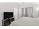 Bedroom with a bed, TV on a stand, and a curtain covering the window with an arched doorway at 8843 Tomnitz Ave # 102, Las Vegas, NV 89178