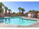 Community pool surrounded by lounge chairs and palm trees on a sunny day at 8843 Tomnitz Ave # 102, Las Vegas, NV 89178