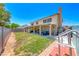 Expansive backyard with a covered patio, lush grass, and a two-story home in the background at 8914 Termoli St, Las Vegas, NV 89123