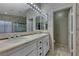Bathroom with large mirrors, a double sink vanity and a shower with glass doors at 8914 Termoli St, Las Vegas, NV 89123