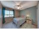 Cozy bedroom with a ceiling fan, plush carpet, a window and blue decorative curtains at 8914 Termoli St, Las Vegas, NV 89123