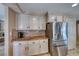 Well-lit kitchen with granite countertops, stainless steel fridge and backsplash plus ample cabinet storage at 8914 Termoli St, Las Vegas, NV 89123