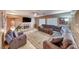 Spacious living room with a fireplace, large sectional sofa, and bright natural light streaming through large windows at 8914 Termoli St, Las Vegas, NV 89123
