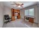 Bright office with a large window, ceiling fan and custom built-in desk and cabinets at 8914 Termoli St, Las Vegas, NV 89123