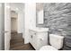 Well-lit bathroom featuring a modern vanity, decorative tile accent wall, and toilet at 901 Allister Fields Ln, Las Vegas, NV 89138