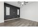 Bedroom with modern gray brick wall, ceiling fan, and natural light from two windows at 901 Allister Fields Ln, Las Vegas, NV 89138