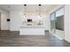 Modern white kitchen with stainless steel appliances, quartz countertops, and stylish pendant lighting at 901 Allister Fields Ln, Las Vegas, NV 89138