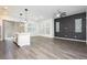 Open-concept living room featuring modern lighting, gray brick wall, and wood-look flooring at 901 Allister Fields Ln, Las Vegas, NV 89138