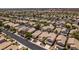 Aerial view showcases an orderly neighborhood featuring houses with uniform designs and desert landscapes at 9017 Iron Hitch Ave, Las Vegas, NV 89143