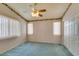 Bedroom with green carpet, ceiling fan, and windows at 9017 Iron Hitch Ave, Las Vegas, NV 89143