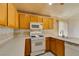 Traditional kitchen featuring oak cabinets, white appliances, and light countertops at 9017 Iron Hitch Ave, Las Vegas, NV 89143