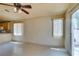 Bright living room with tile flooring, a ceiling fan, and a sliding glass door at 9017 Iron Hitch Ave, Las Vegas, NV 89143