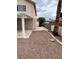 View of the backyard with gravel landscaping, a palm tree, and a covered patio area at 994 River Walk Ct, Henderson, NV 89015