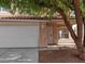 The home's entrance features desert landscaping, a two car garage, and a secure screen door at 994 River Walk Ct, Henderson, NV 89015