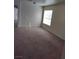 Living room features neutral carpet and paint and a large window for natural light at 994 River Walk Ct, Henderson, NV 89015