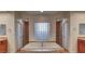 Bathroom featuring a garden tub with tile surround and a glass block window providing natural light at 10829 Ickworth Ct, Las Vegas, NV 89135